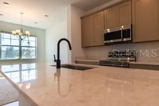a kitchen with stainless steel appliances granite countertop a stove a sink and a microwave