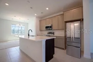 a view of kitchen with refrigerator cabinets and a window