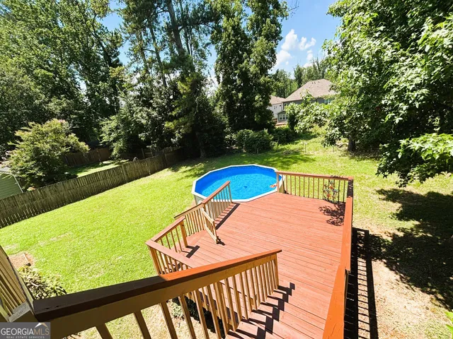 a view of a house with pool and a yard