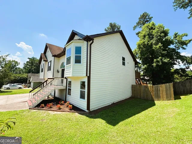 a view of a house with a yard and sitting area