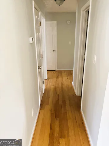 a view of a hallway with wooden floor and staircase