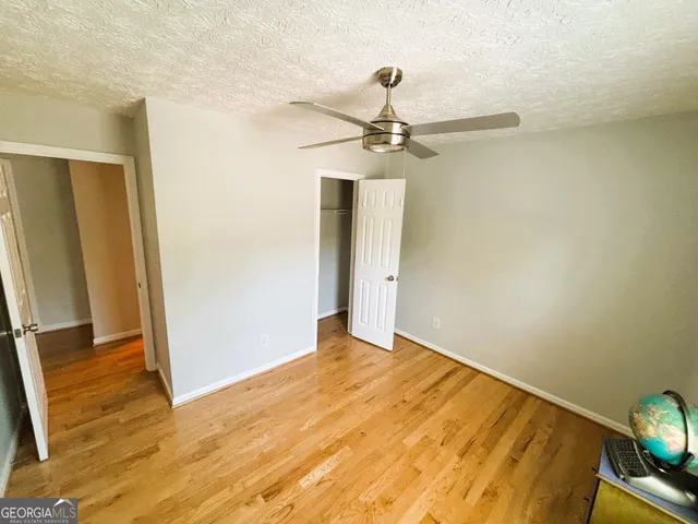 an empty room with wooden floor and closet