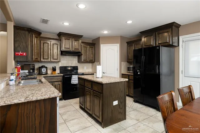 a kitchen with a sink refrigerator and cabinets