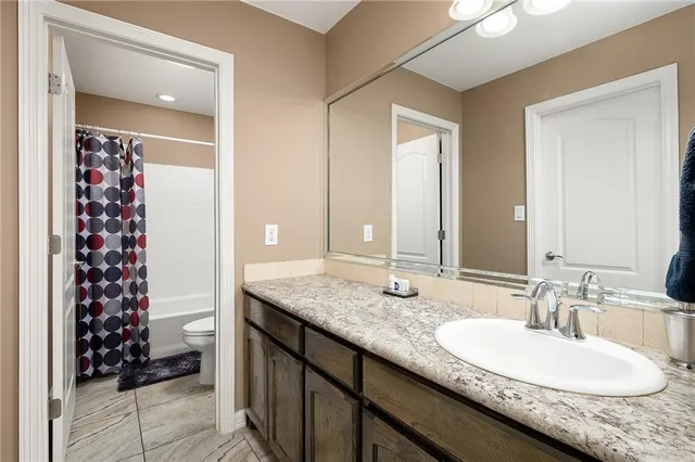 a bathroom with a granite countertop sink a mirror and a shower