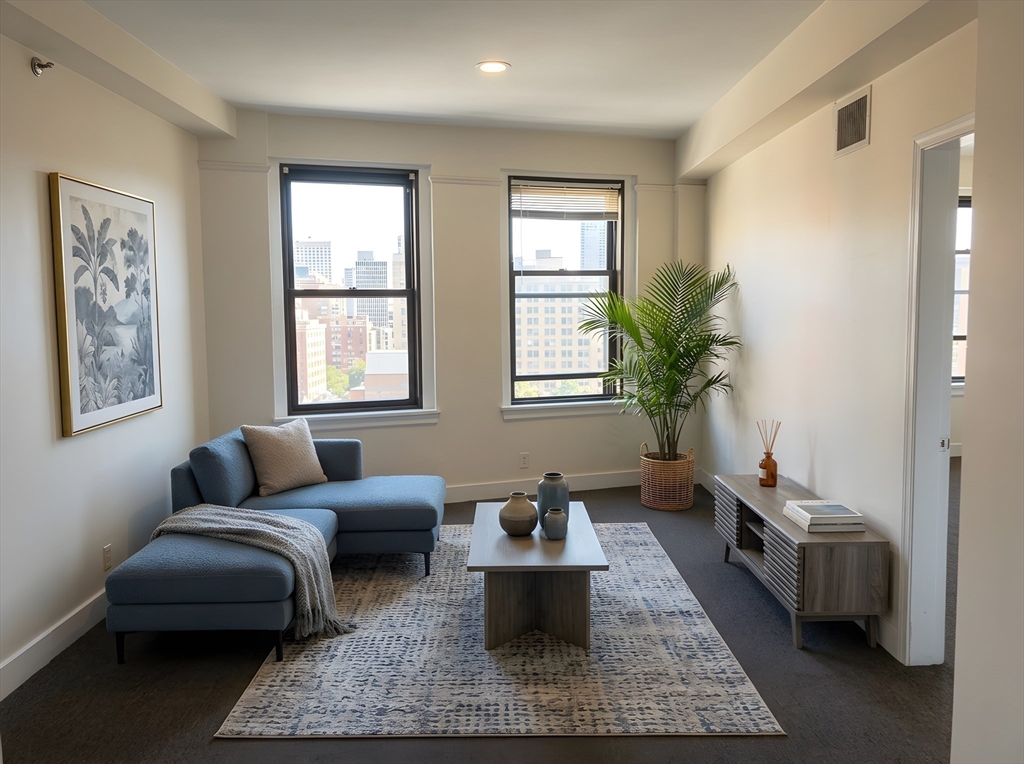 a living room with furniture and a potted plant