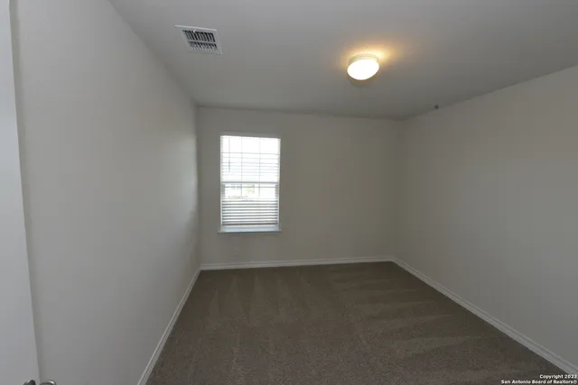 an empty room with a window and a lamp