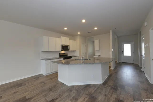 a kitchen with stainless steel appliances a sink a stove a refrigerator and cabinets