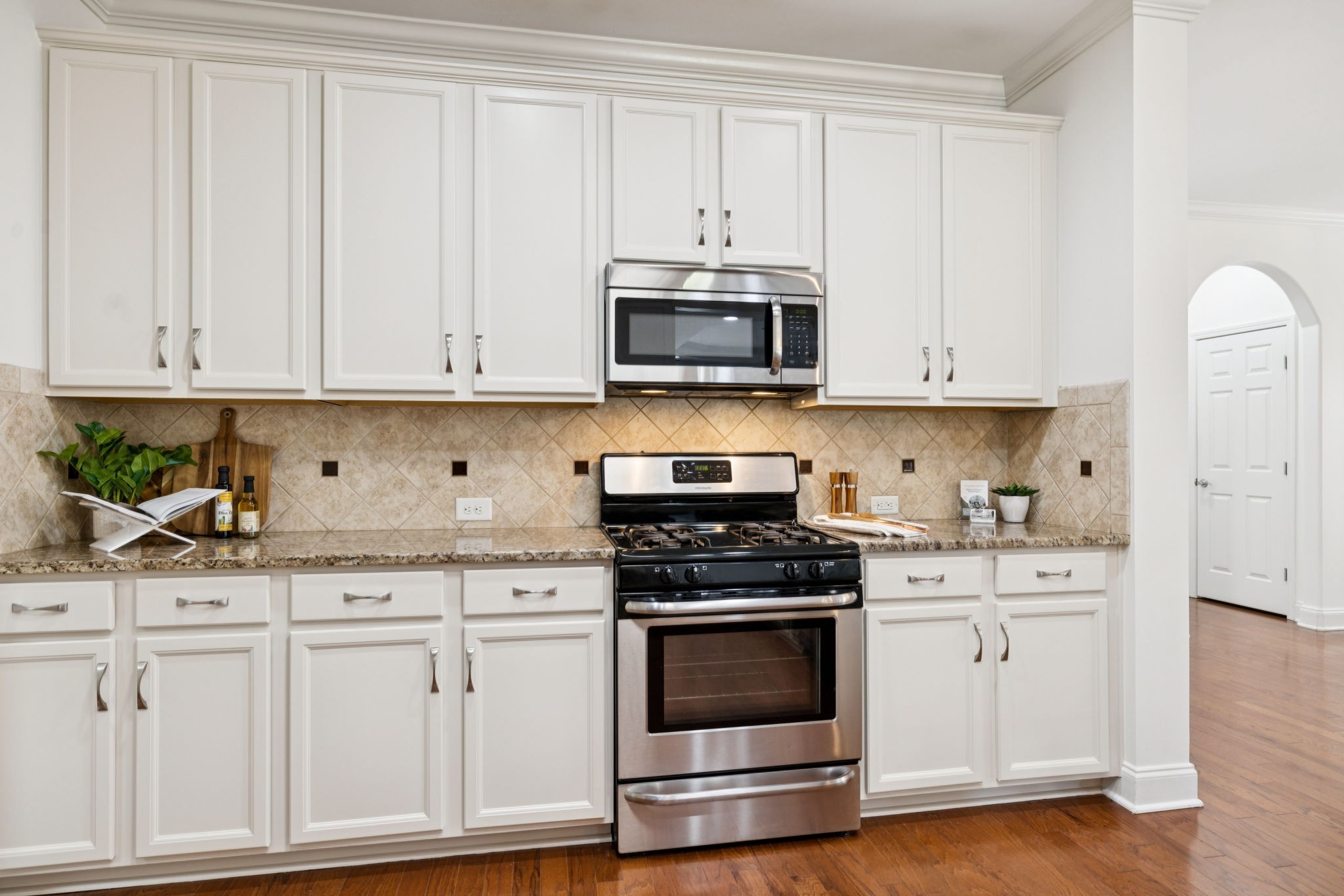 1009 Swanson Lane Franklin, TN 37064 - Photo 25 of 84 a kitchen with granite countertop white cabinets and stainless steel appliances