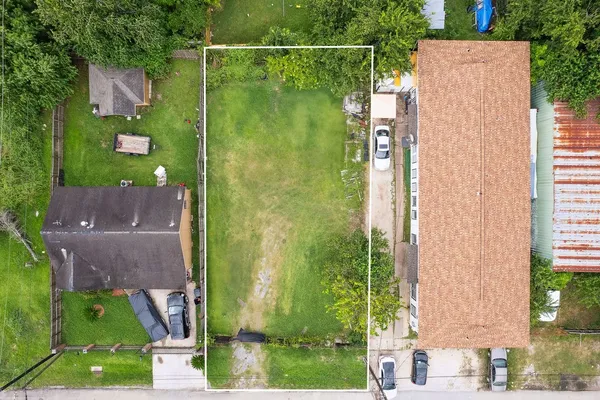an aerial view of residential houses with outdoor space and trees