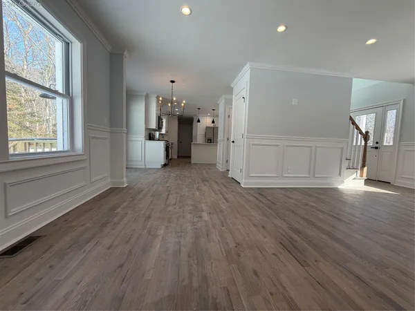 an empty room with wooden floor and windows