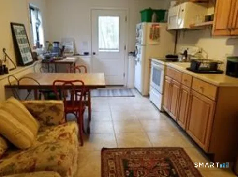 a kitchen with stainless steel appliances granite countertop a refrigerator a stove a sink dishwasher and white cabinets with wooden floor