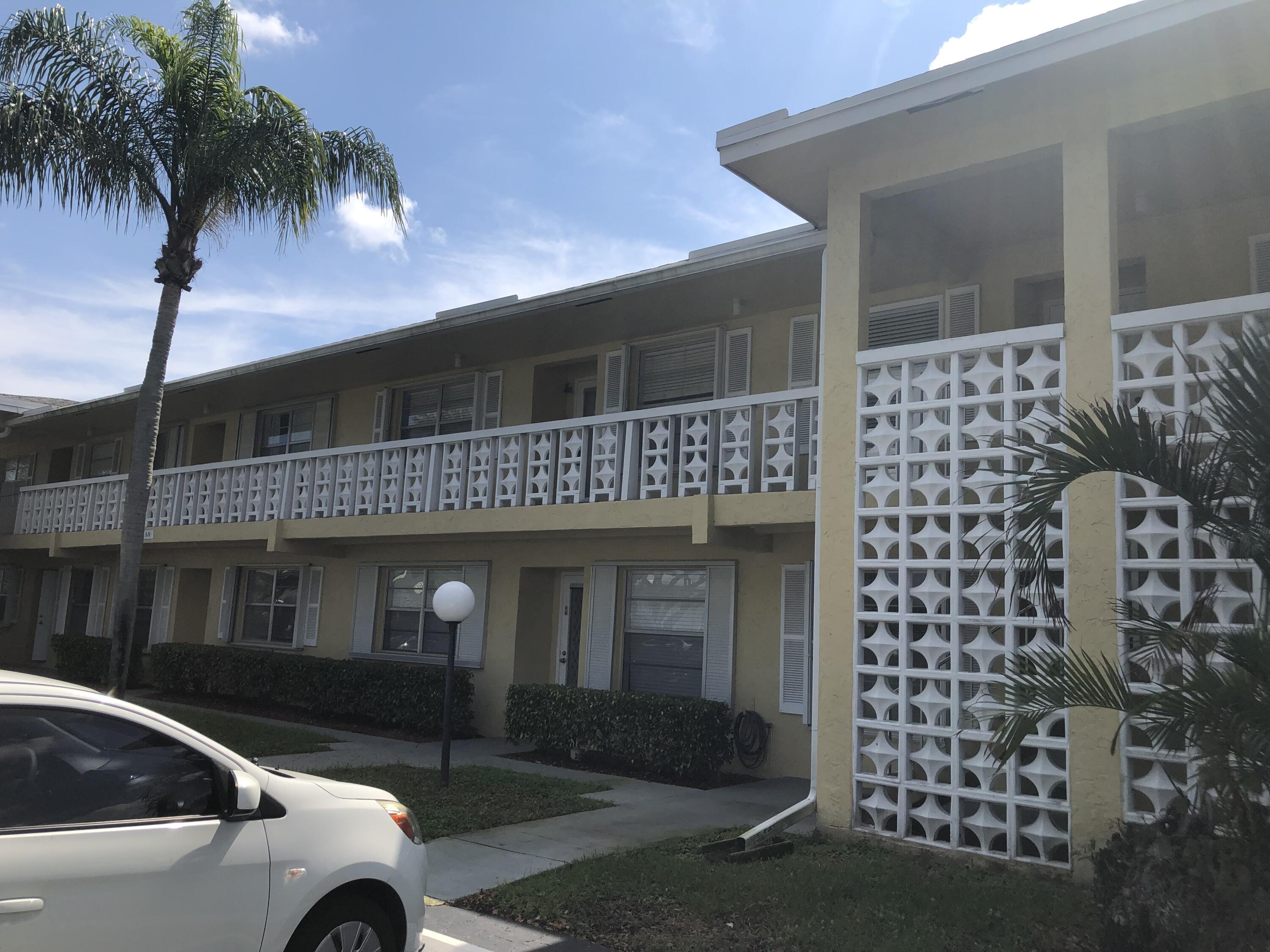 2500 Juniper Drive, Unit 204 Delray Beach, FL 33445 - Photo 1 of 9 a front view of a house with a yard
