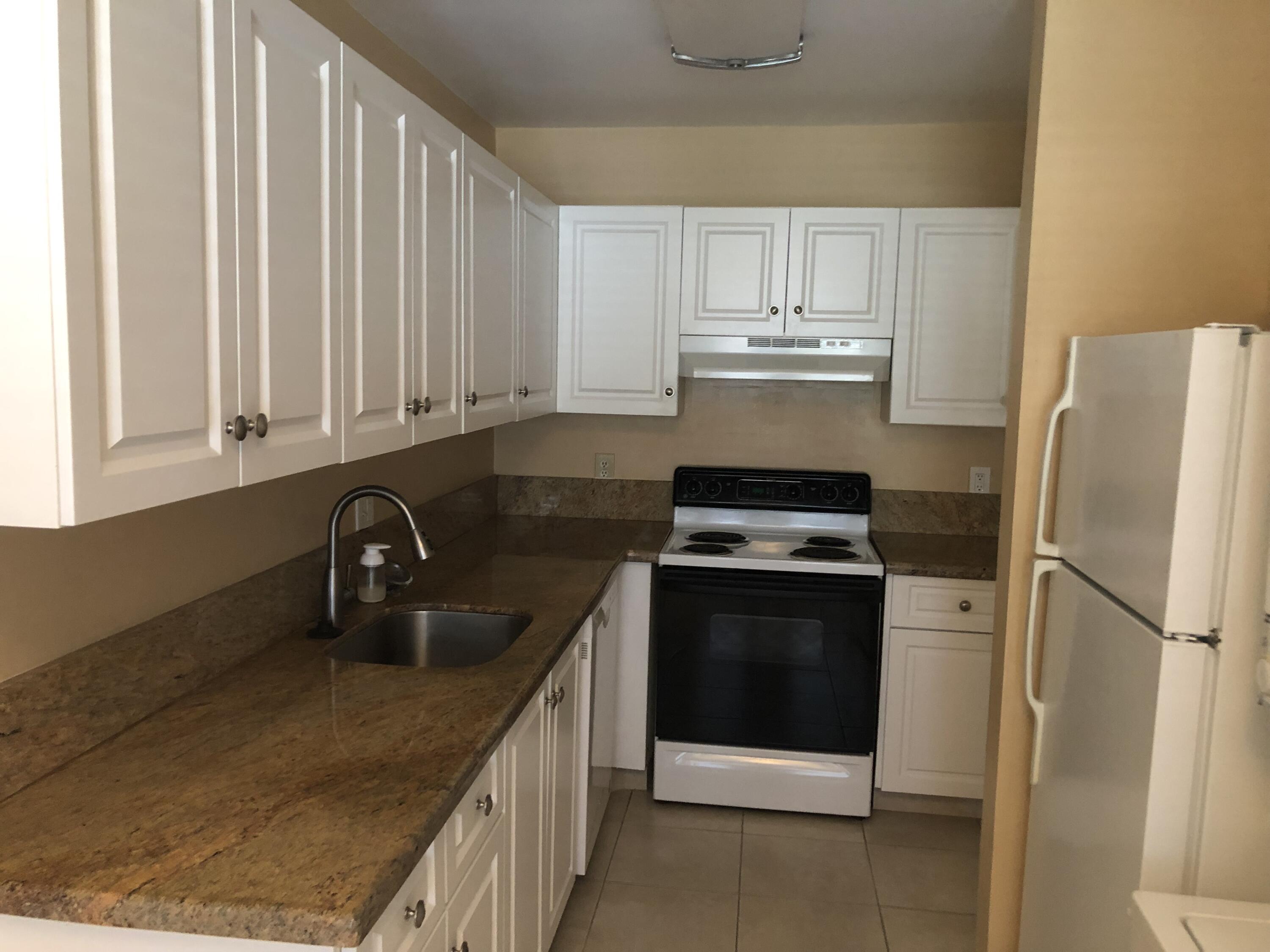 2500 Juniper Drive, Unit 204 Delray Beach, FL 33445 - Photo 2 of 9 a kitchen with stainless steel appliances granite countertop a sink stove and refrigerator