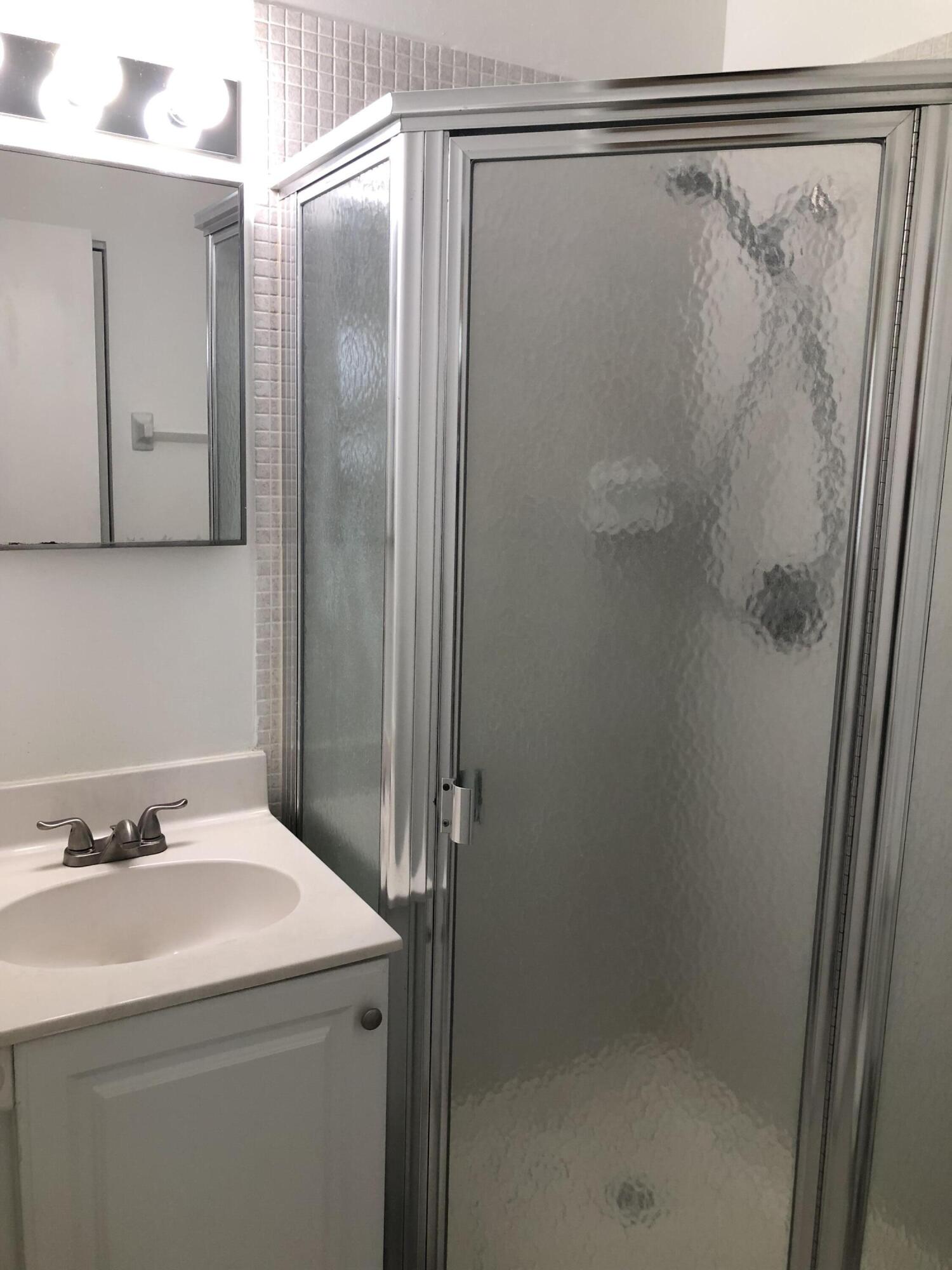 2500 Juniper Drive, Unit 204 Delray Beach, FL 33445 - Photo 5 of 9 a bathroom with a sink and a mirror