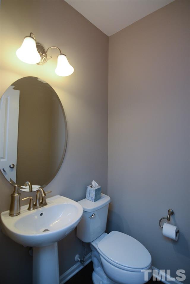 697 Wickham Ridge Road Apex, NC 27539 - Photo 11 of 25 a bathroom with a sink mirror and toilet