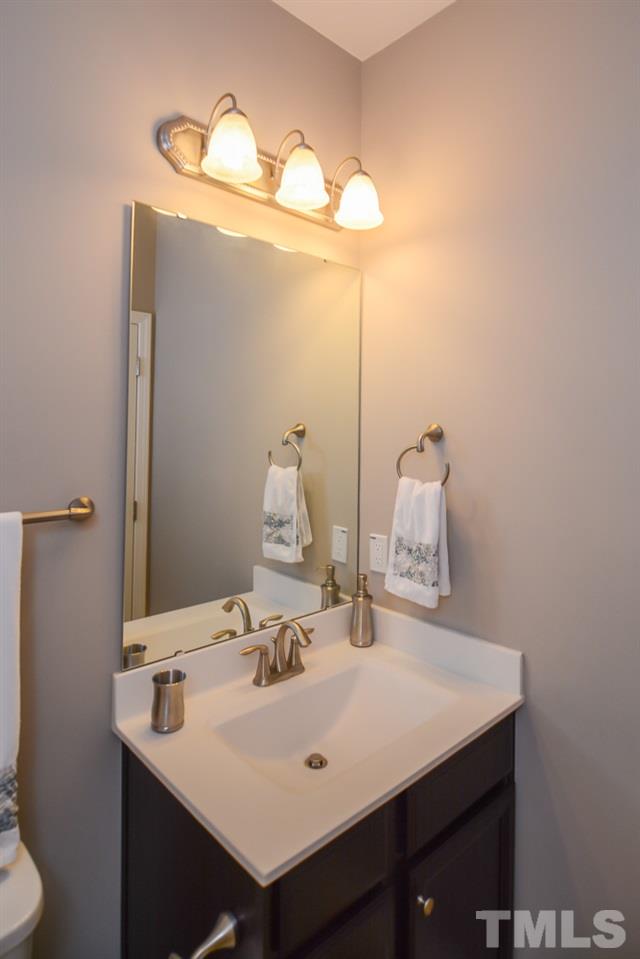 697 Wickham Ridge Road Apex, NC 27539 - Photo 19 of 25 a bathroom with a sink and a mirror