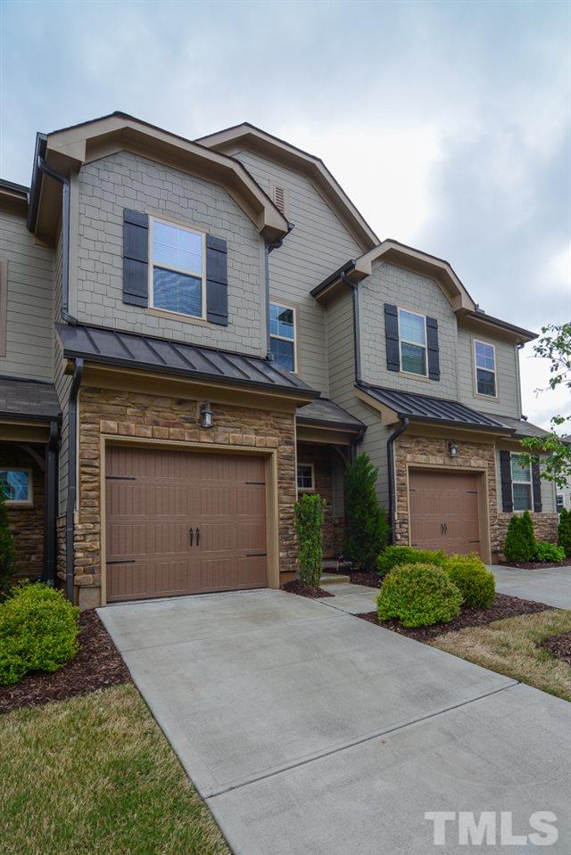 697 Wickham Ridge Road Apex, NC 27539 - Photo 21 of 25 a front view of a house with a garden and garage
