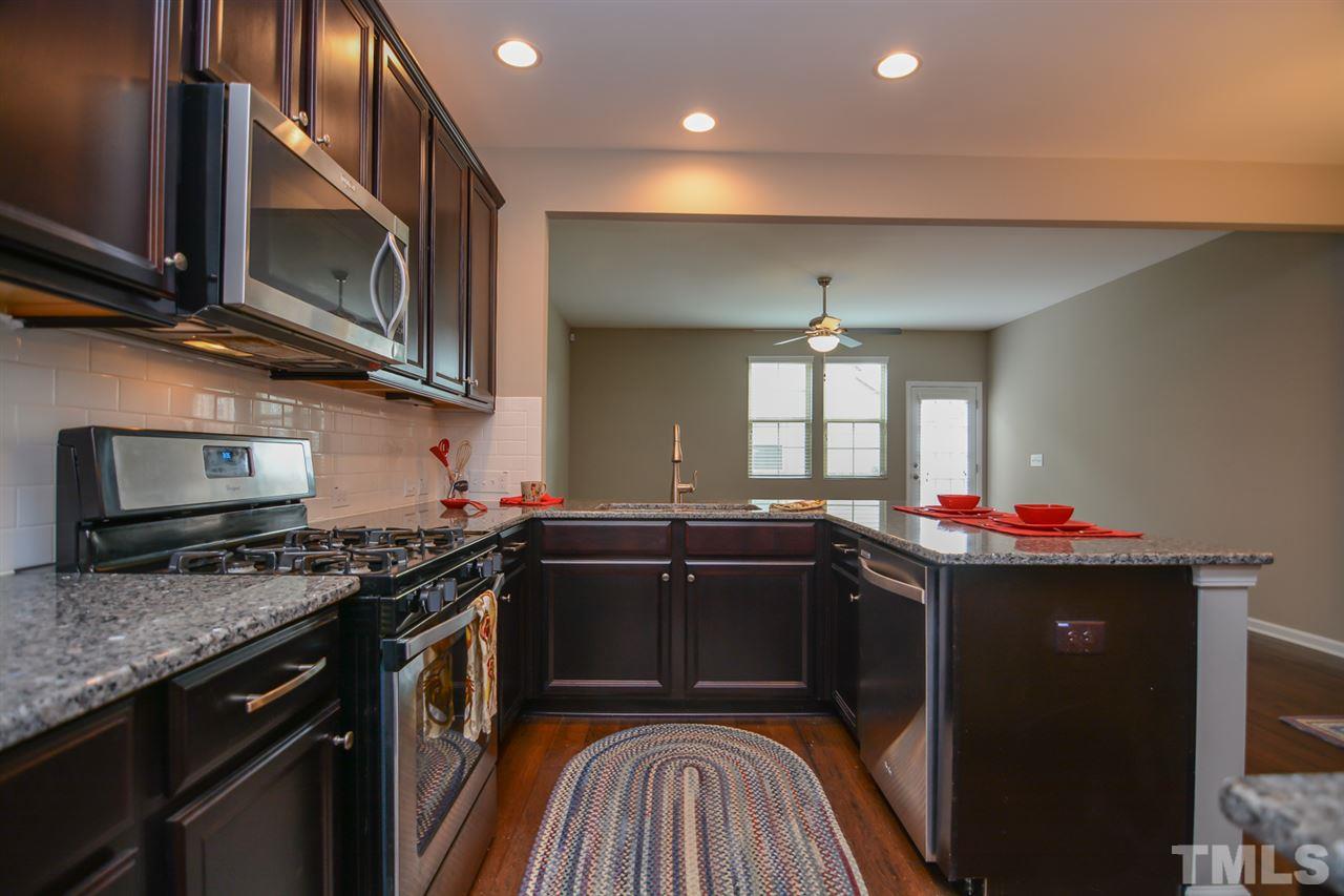 697 Wickham Ridge Road Apex, NC 27539 - Photo 5 of 25 a kitchen with a sink stove and microwave