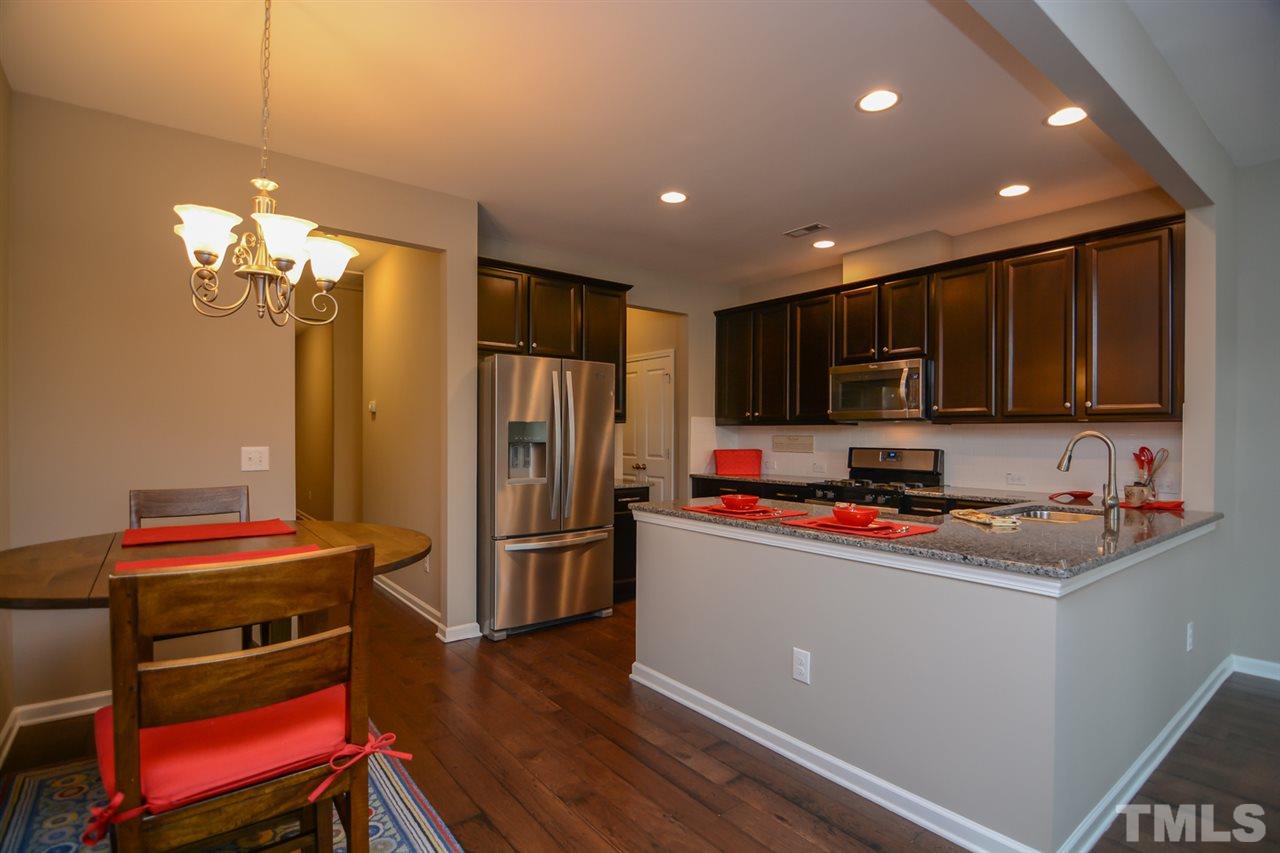 697 Wickham Ridge Road Apex, NC 27539 - Photo 6 of 25 a kitchen with stainless steel appliances a refrigerator sink and microwave
