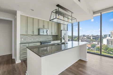 a view of a kitchen with a sink and large window