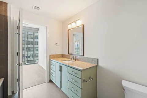 a bathroom with a granite countertop sink and a mirror