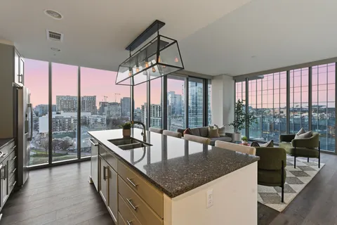 a dining hall with stainless steel appliances granite countertop a couch and chairs