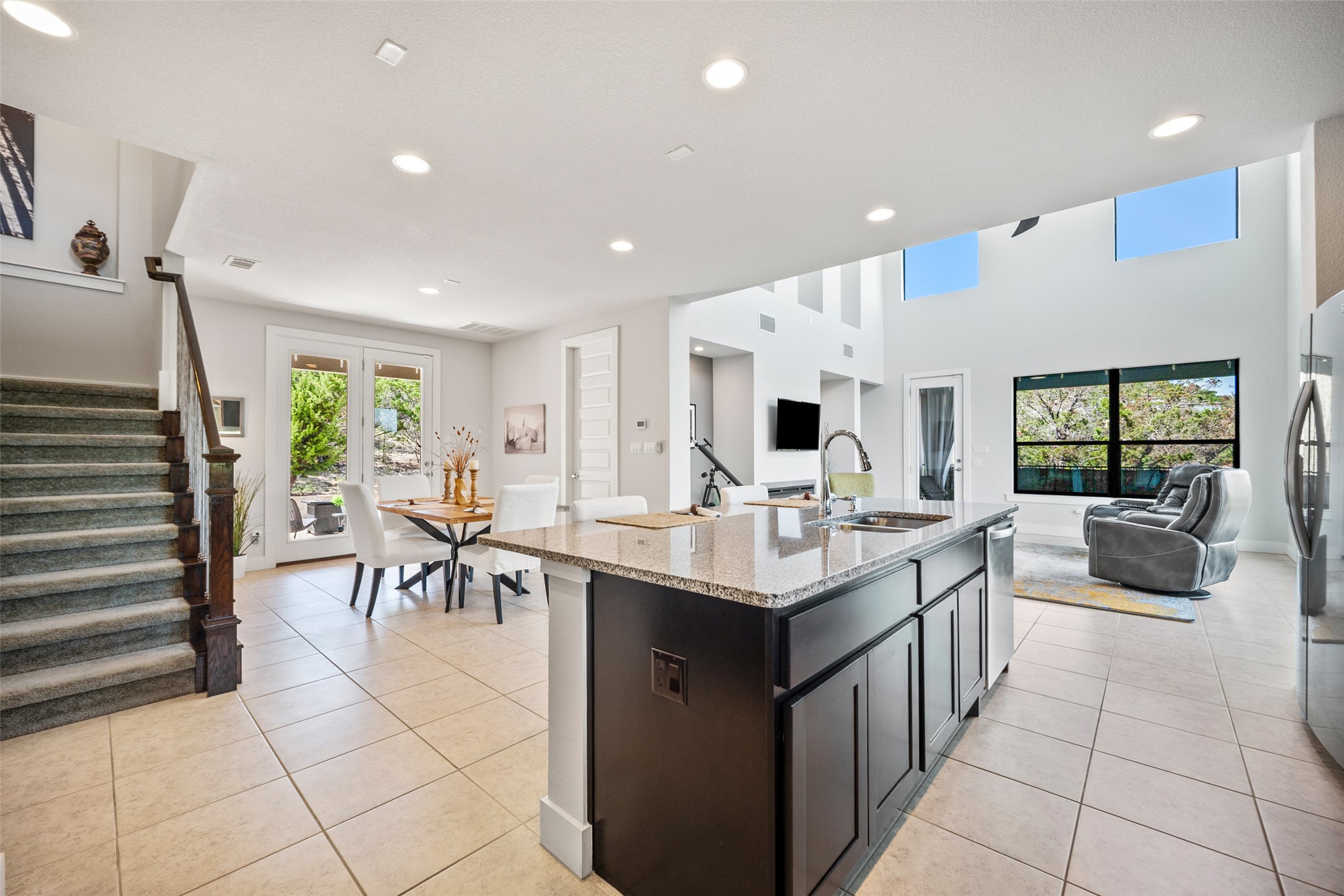 17644 West Reed Park Road Jonestown, TX 78645 - Photo 36 of 36 Kitchen featuring open floor plan, light stone counters, an island with sink, light tile patterned flooring, and recessed lighting