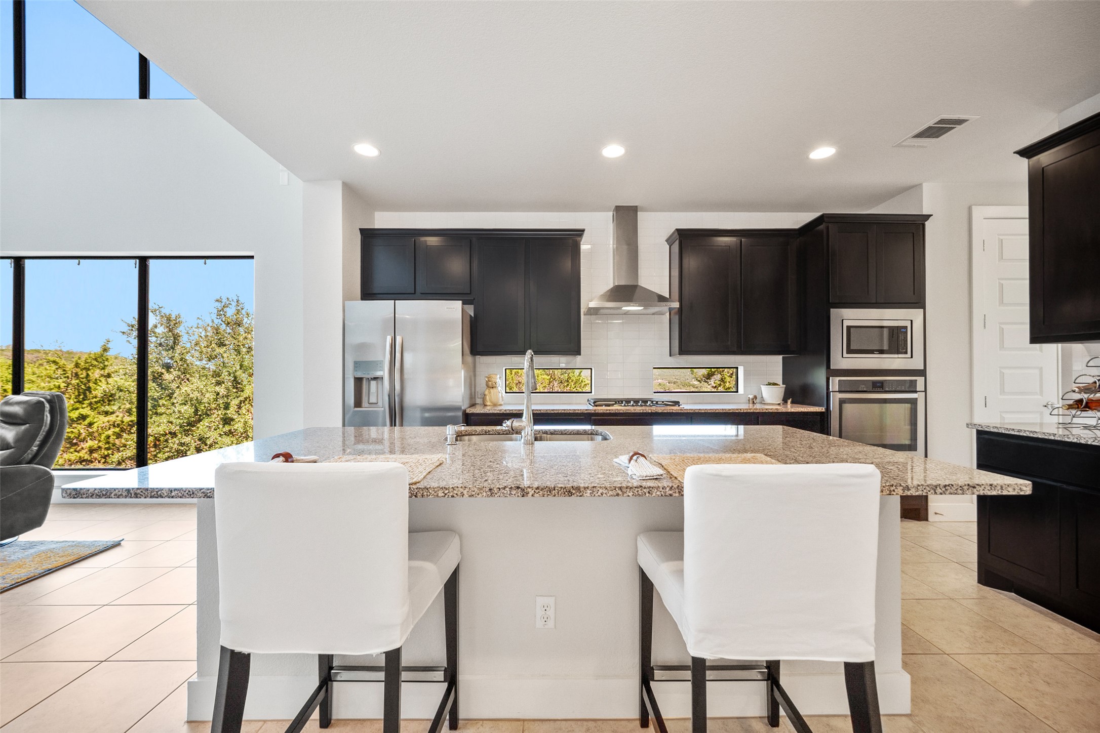 17644 West Reed Park Road Jonestown, TX 78645 - Photo 13 of 36 a kitchen with stainless steel appliances kitchen island granite countertop a sink a stove a refrigerator cabinets and chairs