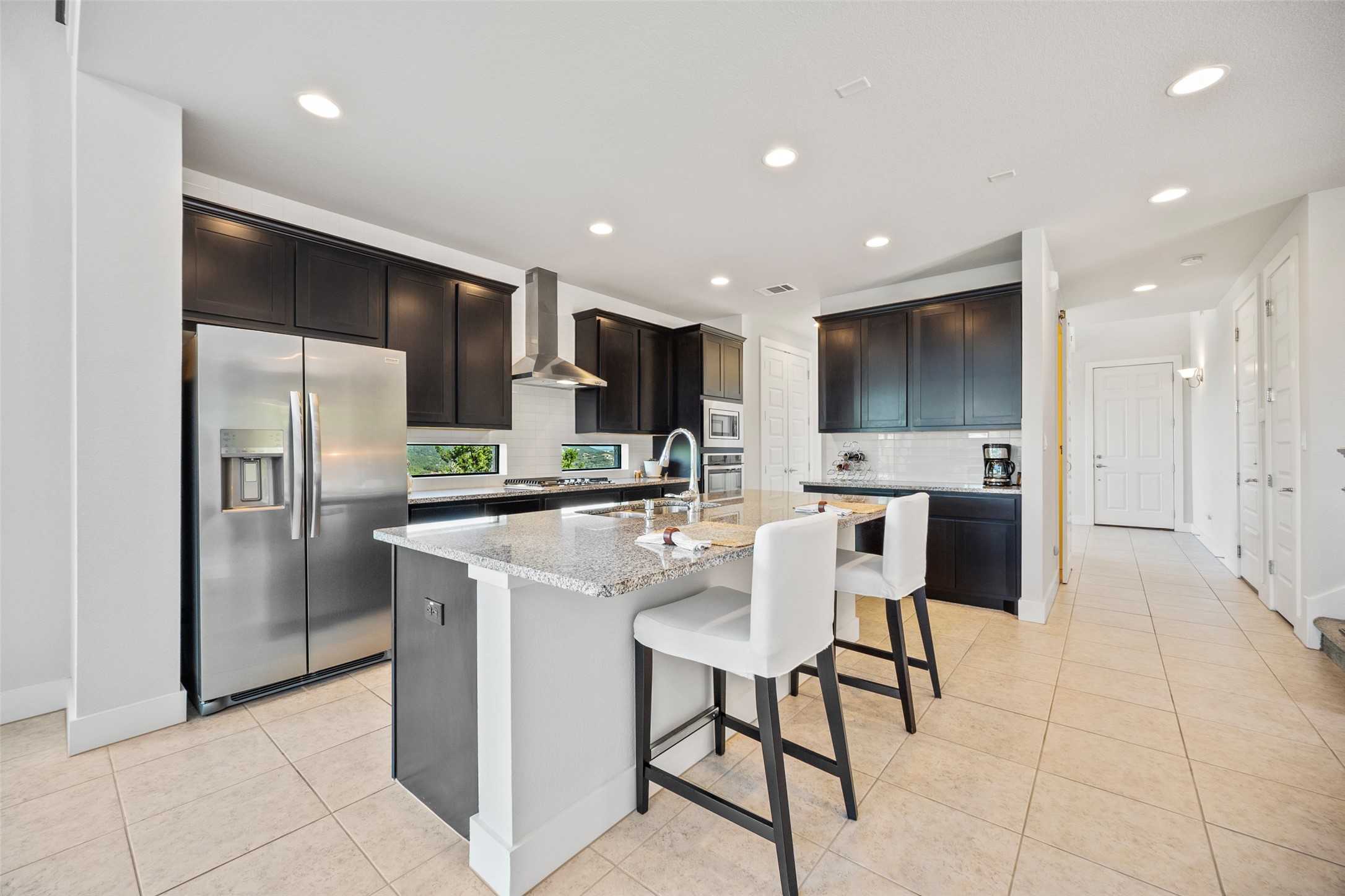 17644 West Reed Park Road Jonestown, TX 78645 - Photo 14 of 36 a kitchen with stainless steel appliances kitchen island granite countertop a refrigerator and a stove top oven