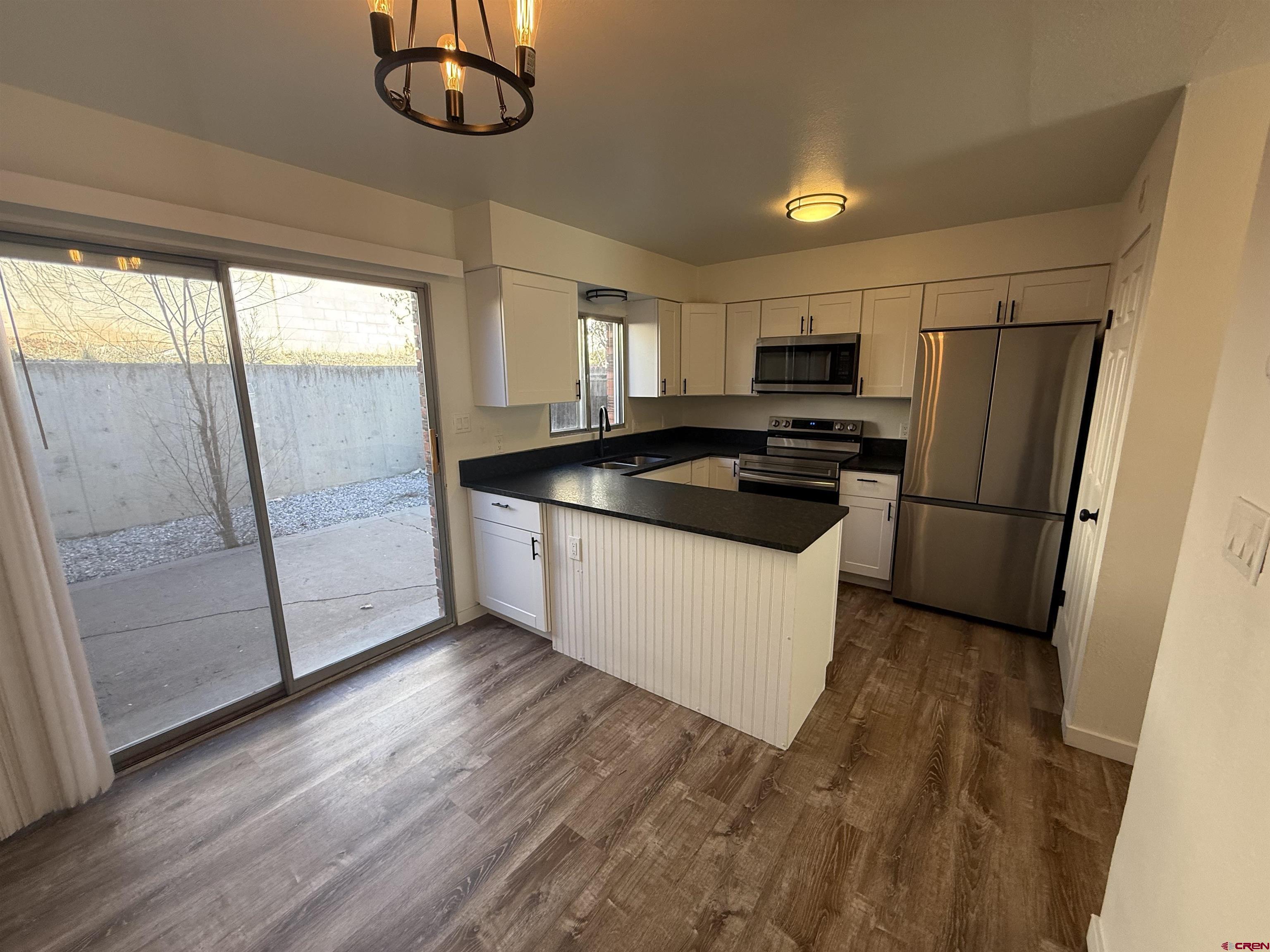 901 Florida Road, Unit 6 Durango, CO 81301 - Photo 19 of 21 a kitchen with stainless steel appliances granite countertop a refrigerator a sink a stove a microwave a counter space and wooden floor