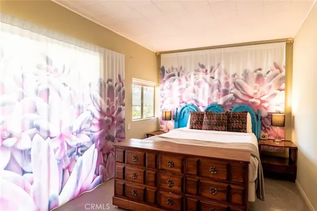 a bedroom with a bed table and window