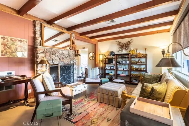 a living room with furniture a fireplace and a floor to ceiling window