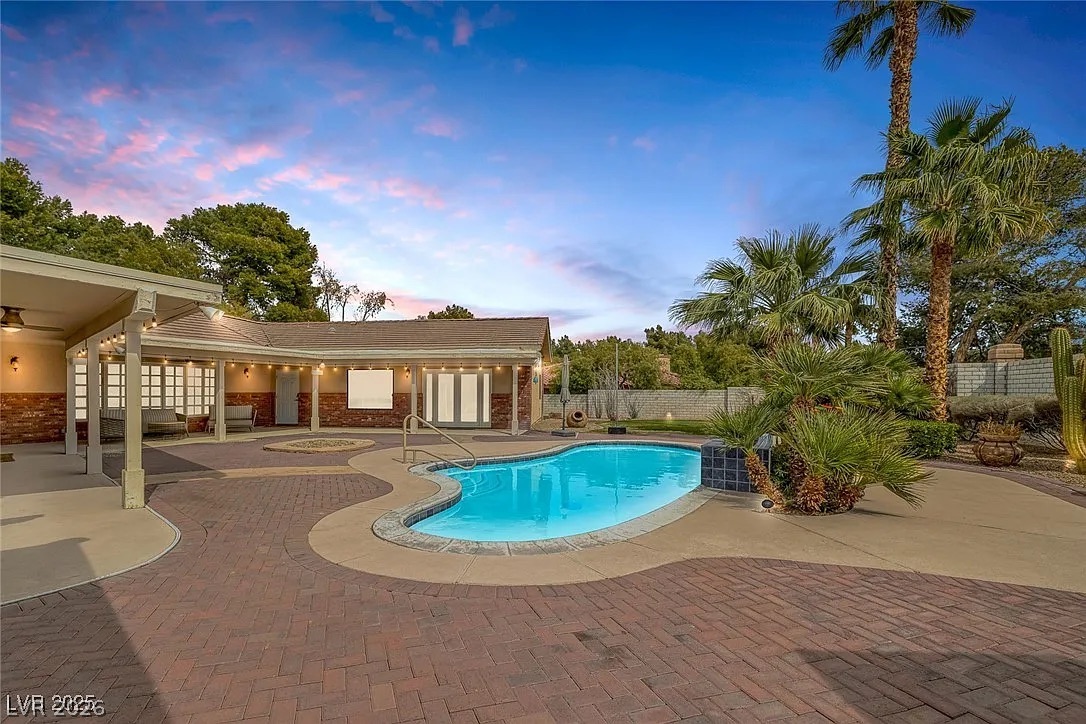 9 Quail Run Road Henderson, NV 89014 - Photo 43 of 57 An inviting backyard oasis showcases a sparkling pool and extensive brick paver patio, perfect for entertaining.