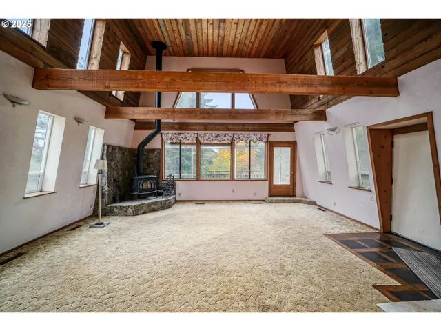a view of an empty room with window and fireplace