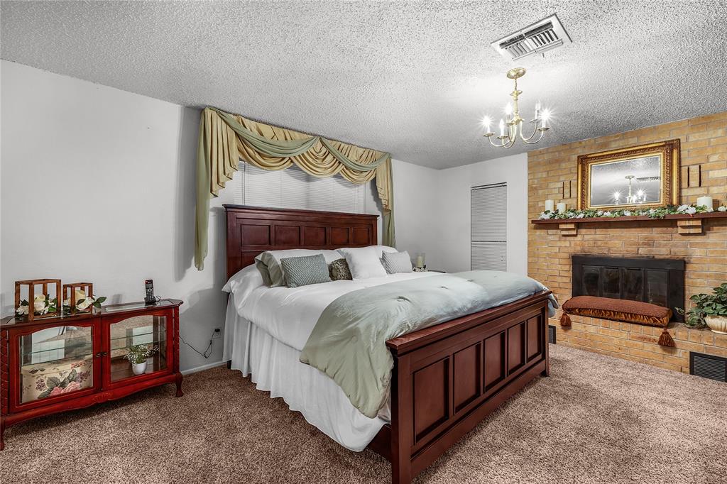 748 Rocky Ridge Lane Weatherford, TX 76085 - Photo 8 of 38 a bedroom with a bed a chandelier and dresser