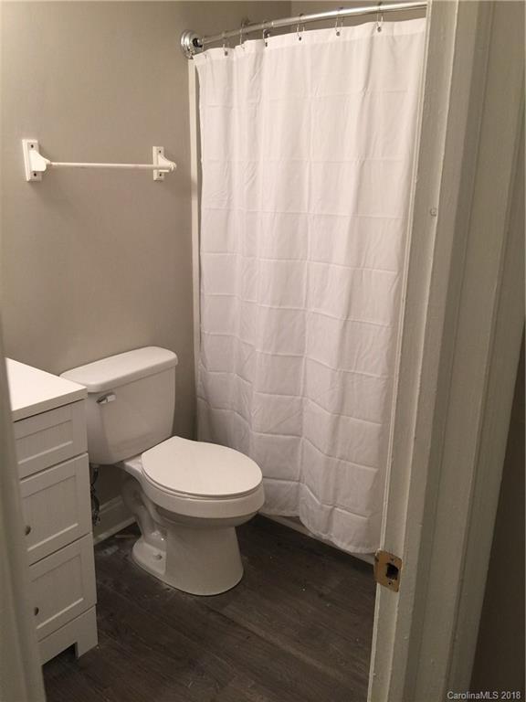 8420 Starnes Randall Road Charlotte, NC 28215 - Photo 9 of 13 a white toilet sitting next to a shower curtain