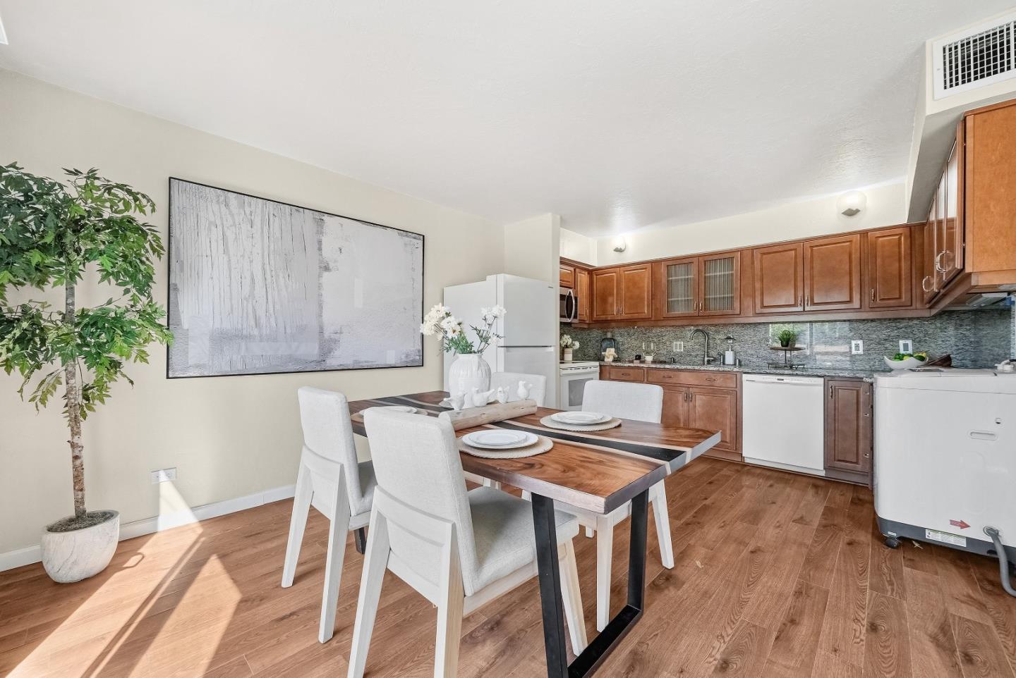 701 North Rengstorff Avenue, Unit 7 Mountain View, CA 94043 - Photo 8 of 32 a kitchen with granite countertop a wooden floor and white cabinets