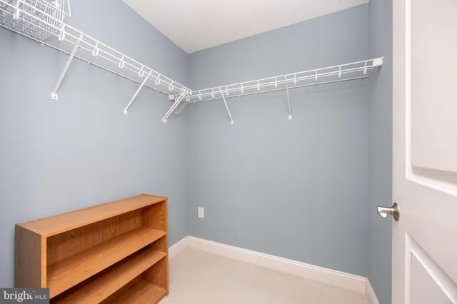 a kitchen with stainless steel appliances granite countertop a stove a sink and white cabinets with wooden floor