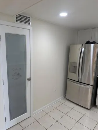 an empty room with windows and chandelier fan