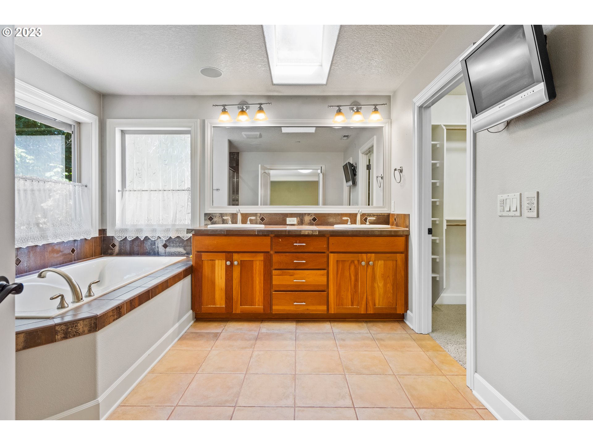 18281 Southwest Florendo Lane Beaverton, OR 97007 - Photo 40 of 47 a spacious bathroom with a granite countertop sink a mirror and a bathtub