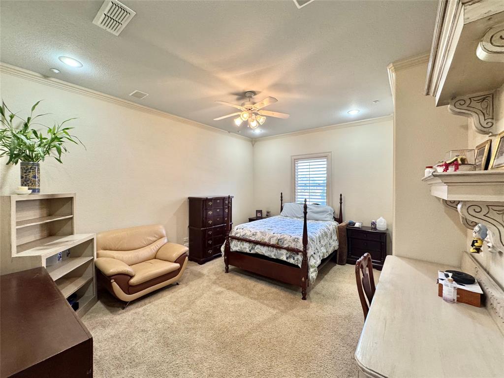 1634 Oak Ridge Drive Corinth, TX 76210 - Photo 17 of 40 a bedroom with furniture and a chandelier