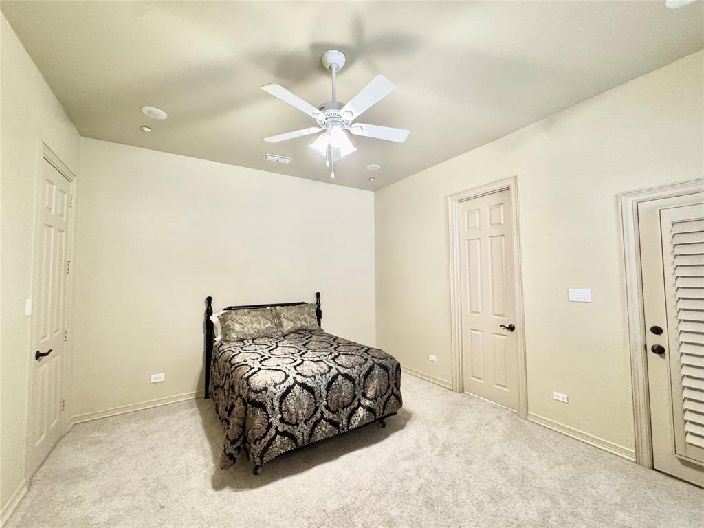 1634 Oak Ridge Drive Corinth, TX 76210 - Photo 28 of 40 a bedroom with a bed and a chandelier