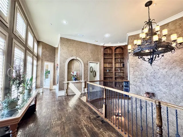a dining room with wooden floor a chandelier a wooden table and chairs