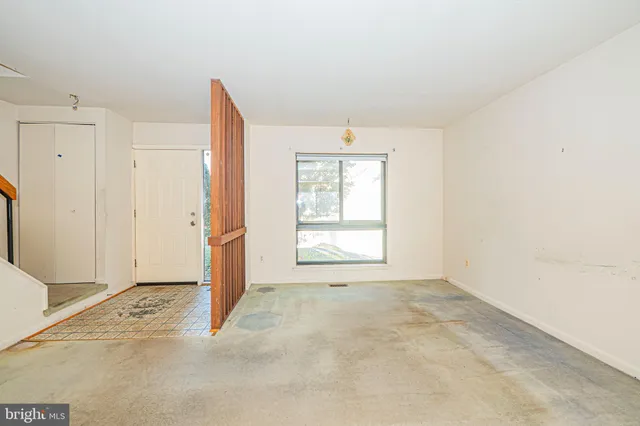 an empty room with windows and closet
