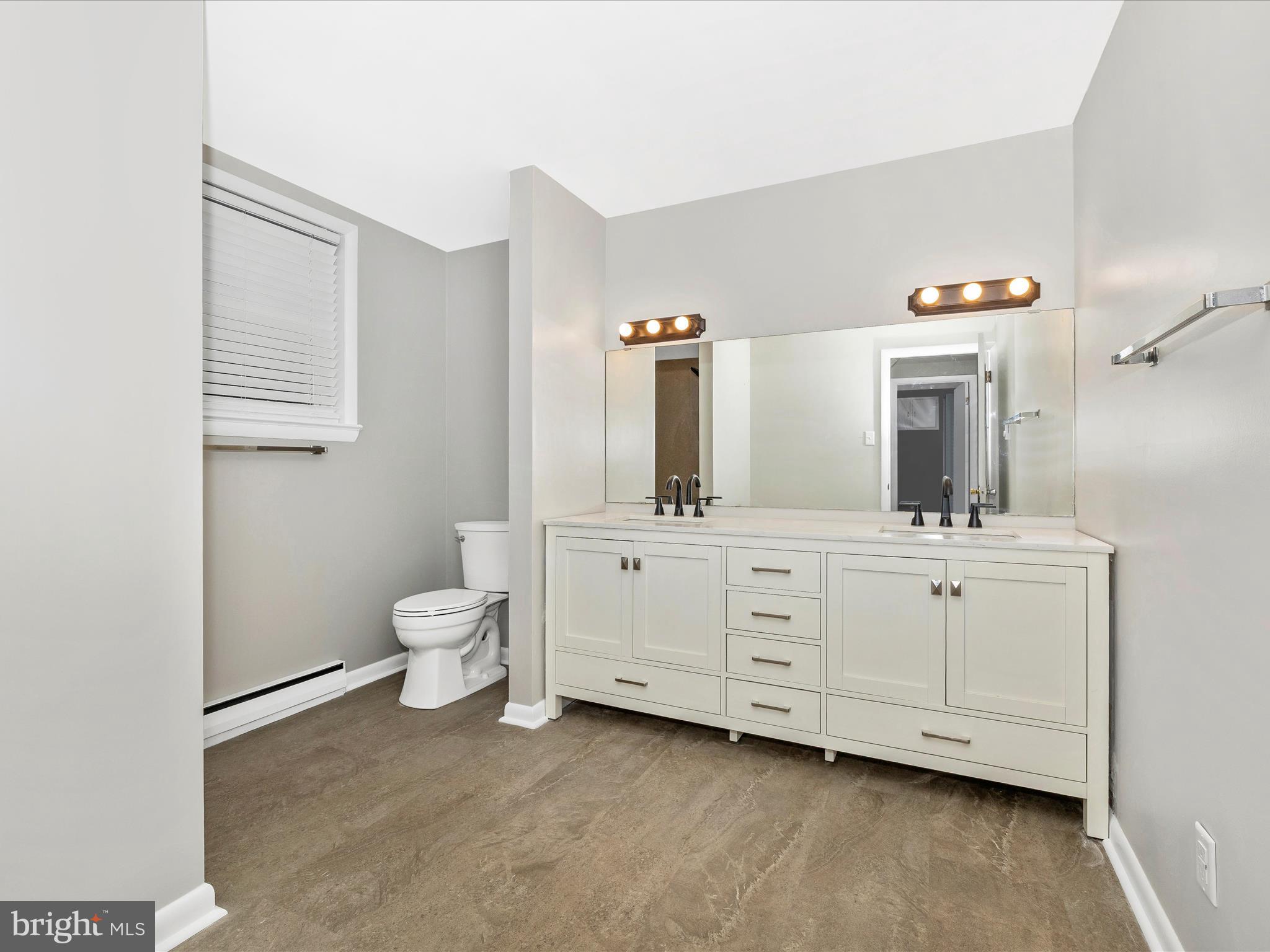 20731 Emerald Drive Hagerstown, MD 21742 - Photo 36 of 54 a bathroom with a double vanity sink a toilet and a mirror