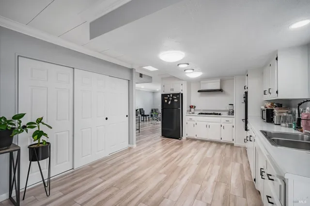 a kitchen with white cabinets and refrigerator