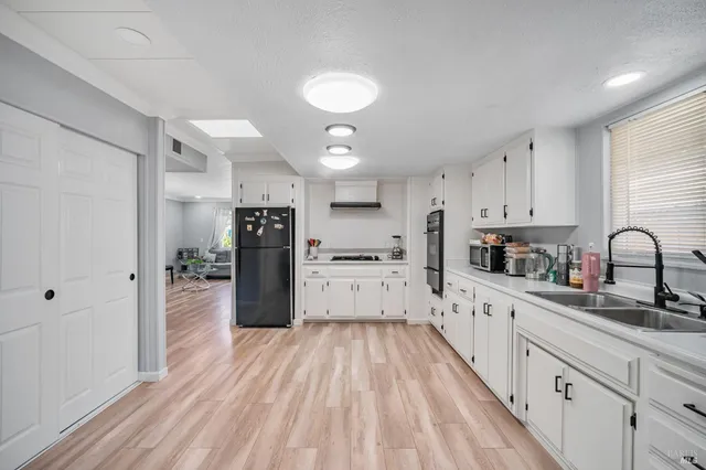 a kitchen with granite countertop a refrigerator stove top oven and sink