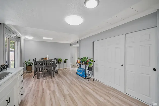 a kitchen with granite countertop a sink stainless steel appliances and white cabinets