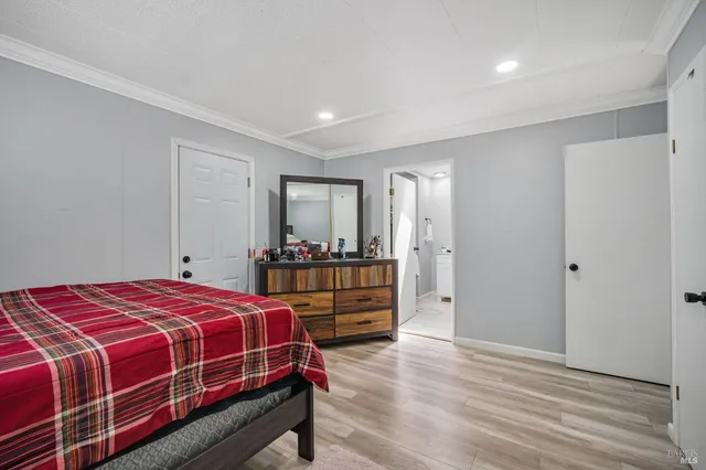 a bedroom with a bed and dresser with mirror