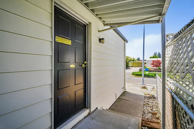 a backyard with potted plants and a wooden bench